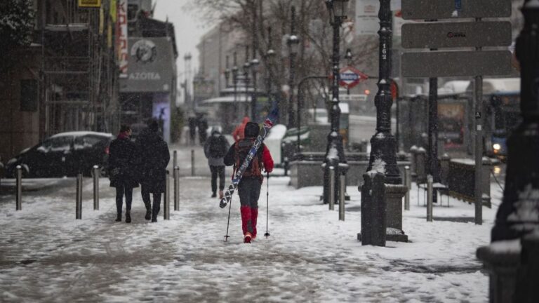 Un hombre camina con un equipo para esquiar en el segundo día de nieve en la capital tras el paso de la borrasca Filomena, en Madrid