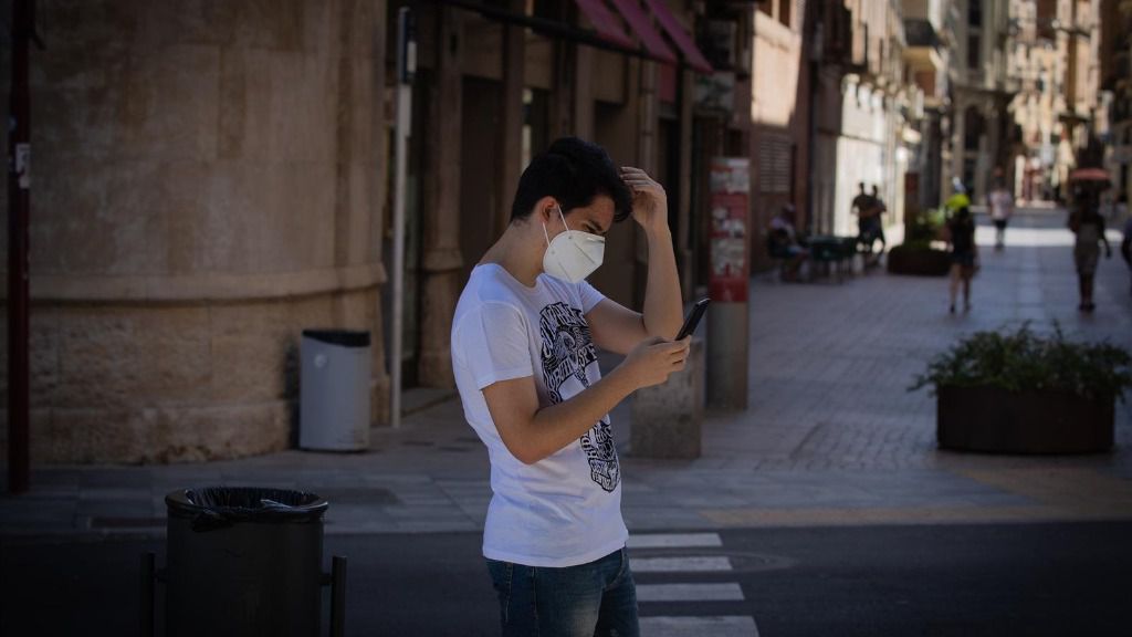 Un joven protegido con mascarilla camina por una calle del centro de Lleida, capital de la comarca del Segrià, en Lleida, Catalunya