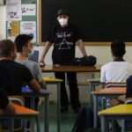 Un profesor y alumnos en un aula en el inicio del curso escolar en Roma