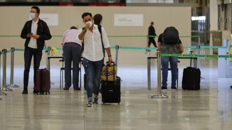 Pasajeros procedentes de Londres rellenan un formulario a su llegada a Barajas