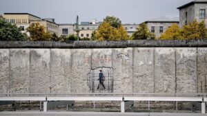 Un hombre con pasando ante un muro de un museo en Niederkirchnerstrasse, en Berlín alemania / Foto: Britta Pedersen - dpa-Zentralbild