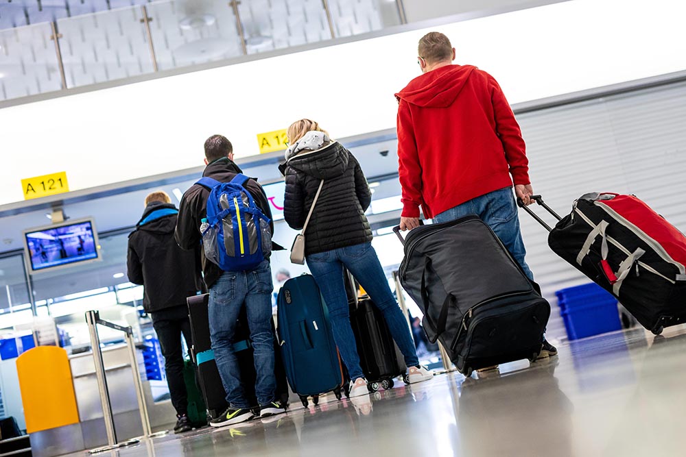 Pasajeros en el aeropuerto de Hanover aguardan su turno para embarcar rumbo a la popular isla española de Mallorca. Foto: Moritz Frankenberg/dpa