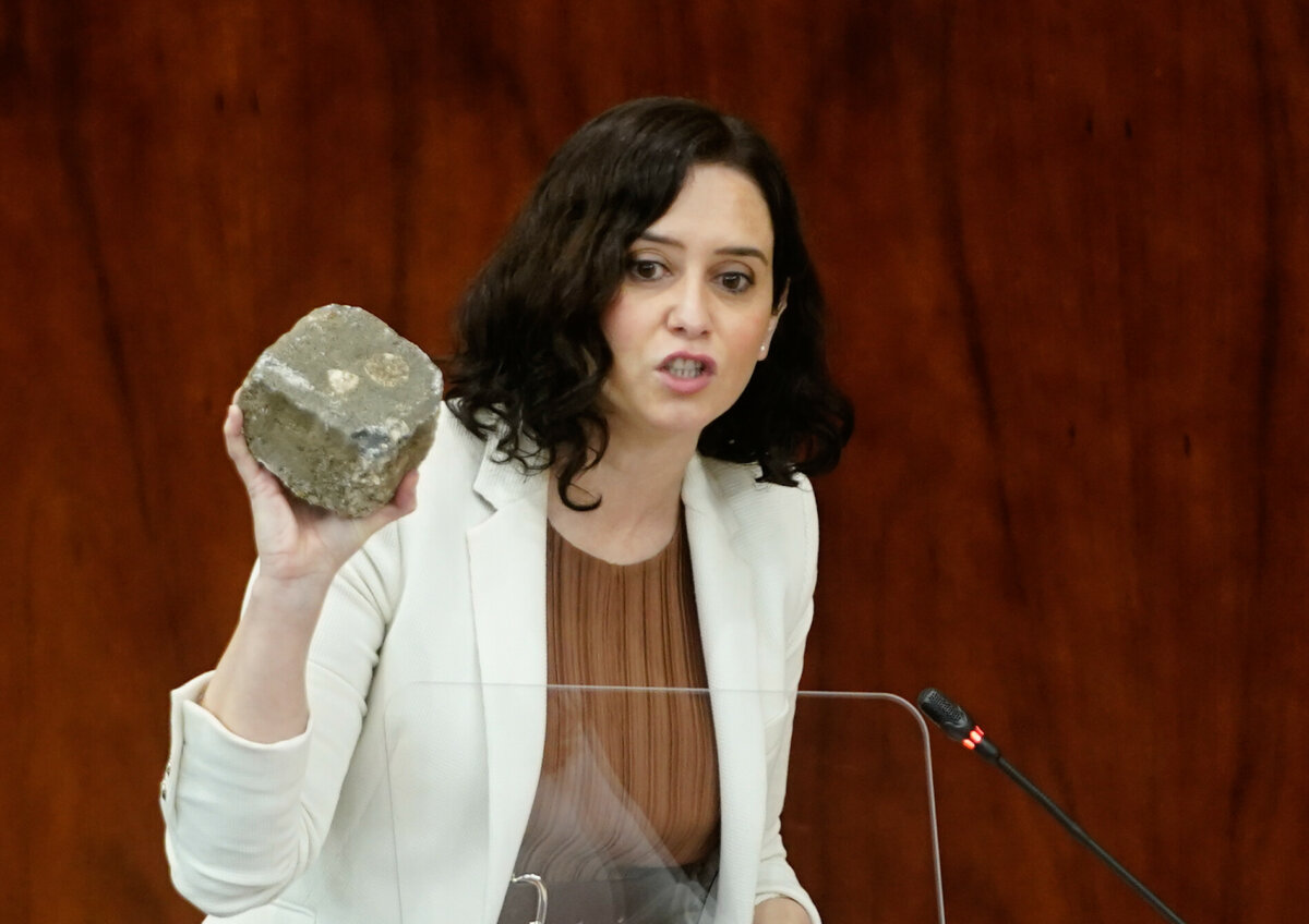 Isabel Díaz Ayuso muestra un adoquín en la Asamblea.