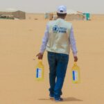 Un trabajador lleva botellas de aceite vegetal del PMA para distribuirlas entre los desplazados internos en un campamento de Yemen - PMA / HANI SALEH