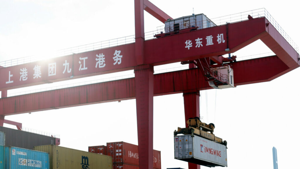 Imagen de una grupo portando un contenedor en un puerto en China. - EXTENDA
