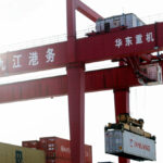 Imagen de una grupo portando un contenedor en un puerto en China. - EXTENDA