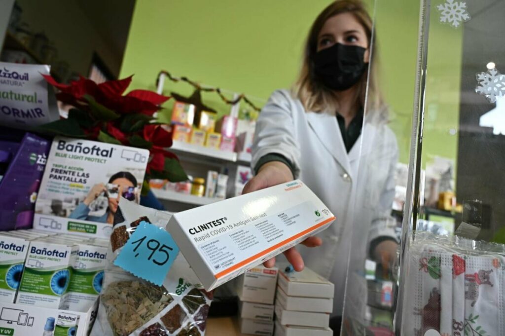 Una farmacéutica muestra el último test de antígenos que tiene disponible a la venta en su farmacia de Madrid. / EFE/ Fernando Villar
