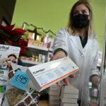 Una farmacéutica muestra el último test de antígenos que tiene disponible a la venta en su farmacia de Madrid. / EFE/ Fernando Villar