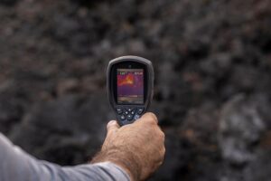 Un hombre mide la temperatura de una colada de lava, en la zona de exclusión próxima al volcán de Cumbre Vieja. - Alexandre Diaz - Europa Press