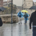 Dos personas con paraguas y chubasqueros caminan bajo la lluvia, a 3 de mayo de 2022, en València. - Rober Solsona - Europa Press