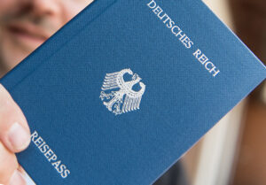 Un hombre sostiene en la mano un cuadernillo en el que se lee: Pasaporte del Reich (imperio) alemán / Foto: Patrick Seeger - dpa