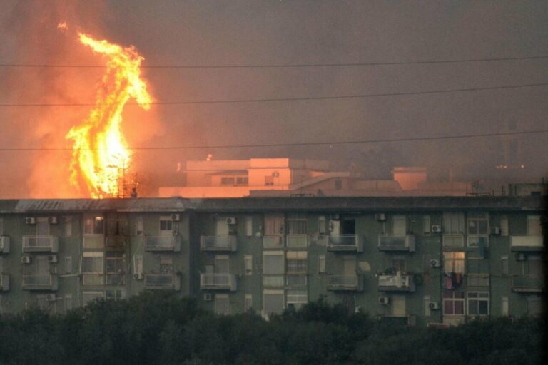 Una columna de fuego se eleva tras un bloque de viviendas en el área de Monte Grifone en la ciudad de Ciaculli, cerca de Palermo. / EFE