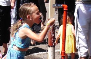 Niña bebiendo agua de una fuente