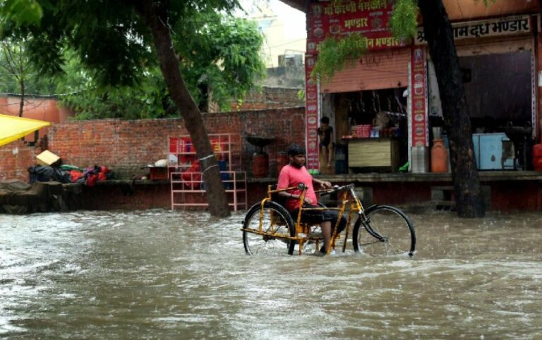 Joven con discapacidad se desplaza en una calle inundada | Foto de Mukesh Kumar Jwala/Shutterstock