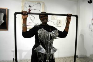 Winnie Byanyima, directora ejecutiva de ONUSIDA, tras un corset de Cristian Caicedo durante su visita a exposición La Vida en Positivo. / Aser G. Rada