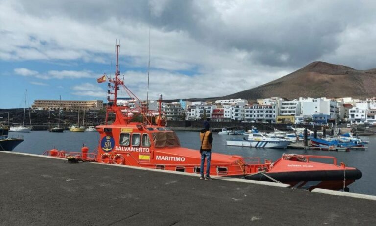 Imagen de un migrante rezando en el puerto de La Restinga (Hierro) frente a una embarcación de Salvamento Marítimo / Foto: Caminando Fronteras