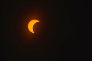 Solar eclipse in dark red glowing sky, amazing scientific background