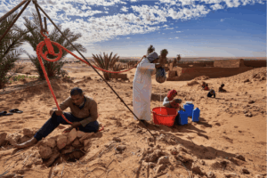 En pleno desierto, un grupo de personas trabajan juntas para extraer agua de un pozo tradicional mediante un sistema manual de poleas (Foto: Abdallah Khalili / UNCCD)