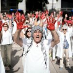 ecenas de personas con las manos pintadas de rojo durante un homenaje al personal sanitario que trabaja en Gaza, frente al Museo de Arte Contemporáneo (Foto: Diego Radamés - Europa Press)