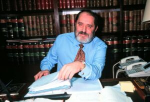 Emilio Rodríguez Menéndez en su oficina rodeado de libros legales