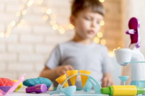 Niño jugando con juguetes creativos en una mesa.