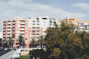 Edificios residenciales en Valencia con palmeras y un cielo despejado.