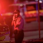 Un agente de la Policía australiana habla por teléfono tras el tiroteo masivo en la playa de Bondi, en Sídney. Se cree que varias personas han muerto después de que hombres armados abrieran fuego contra una multitud reunida en la playa de Bondi. - Jeremy Piper/AAP/dpa