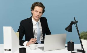 Hombre en traje sentado en oficina moderna con computadora