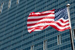 Bandera de Estados Unidos ondeando frente a un edificio moderno