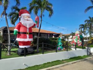Decoración navideña con Santa Claus inflable y árboles en un jardín