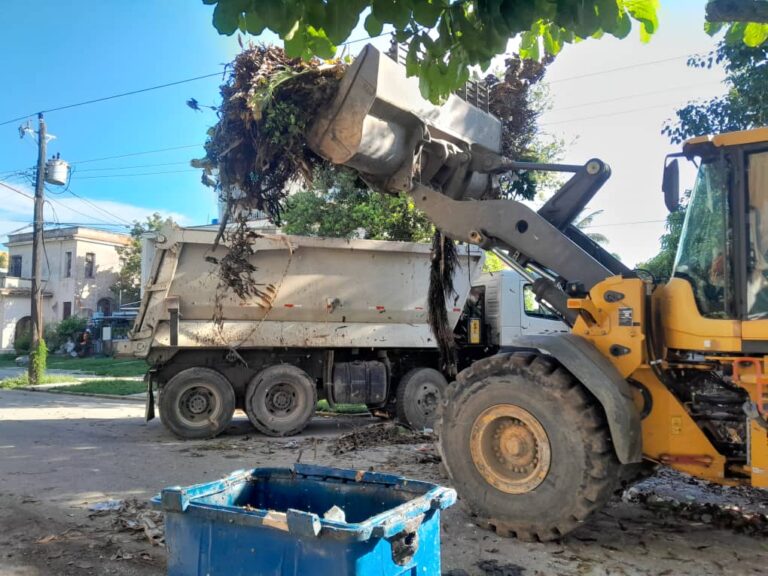 Máquina de construcción levantando desechos en La Habana