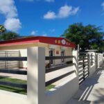 Edificio con cercas y vegetación en un día soleado