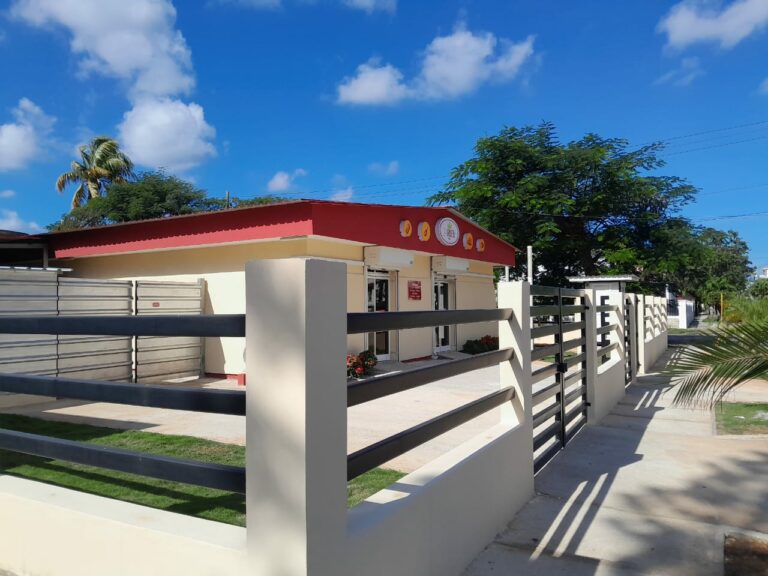 Edificio con cercas y vegetación en un día soleado