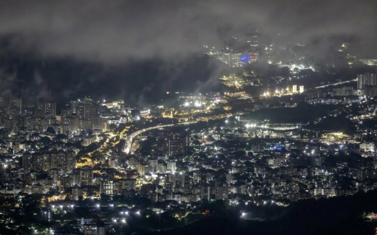 Vista nocturna de Caracas iluminada con nubes en el cielo