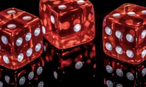 Tres dados rojos brillantes sobre una superficie reflectante