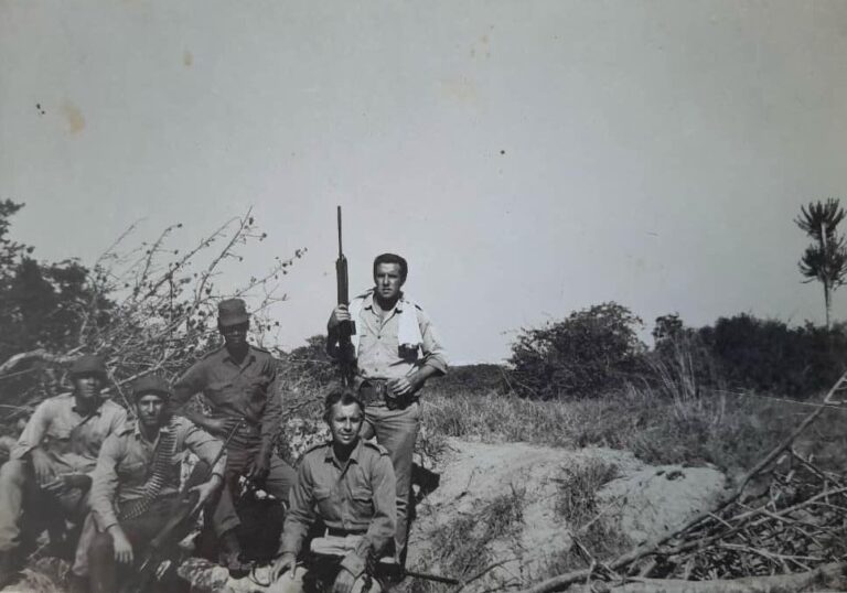 Grupo de hombres armados en un paisaje natural