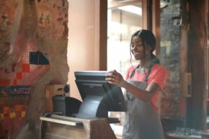 Mujer sonriente usando un sistema TPV en un restaurante