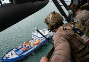 Militares observando un petrolero desde un helic&oacute;ptero en el mar