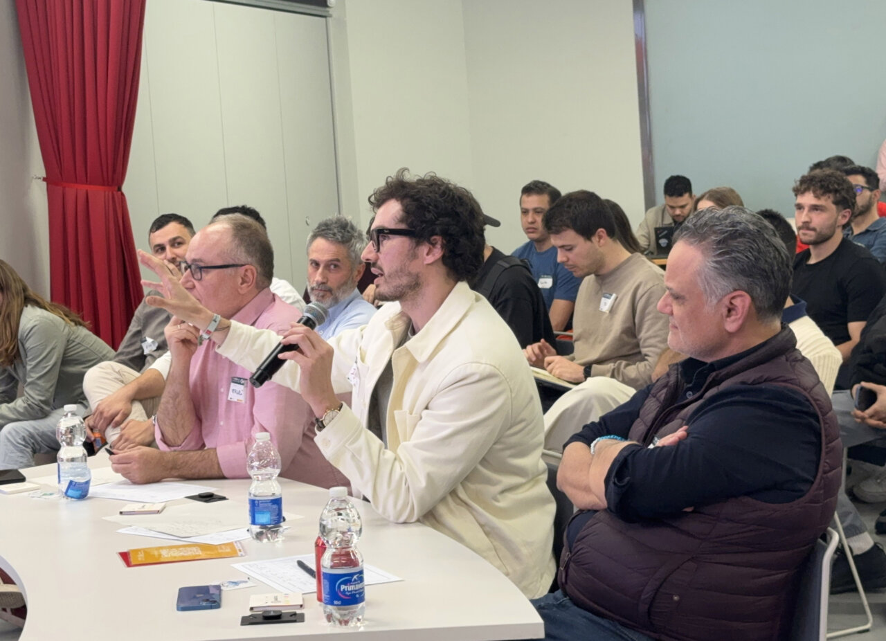 Participantes del jurado en el hackathon de Madrid discutiendo soluciones tecnol&oacute;gicas.