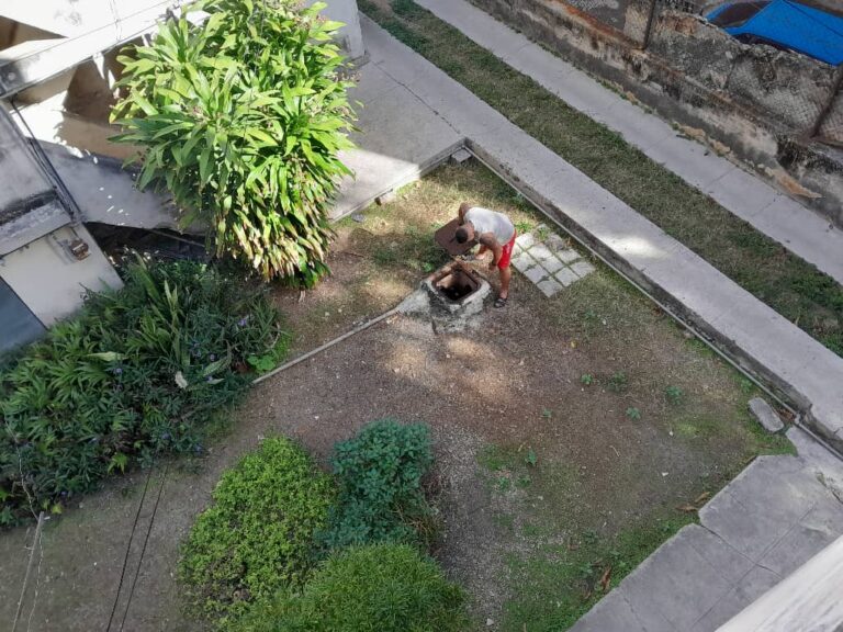 Residente revisando una cisterna en un edificio en Cuba