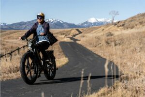 Ciclista montando una bicicleta el&eacute;ctrica de monta&ntilde;a en un camino