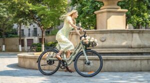 Mujer montando una bicicleta el&eacute;ctrica Fiido con correa dentada en un entorno urbano.