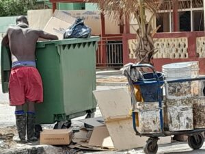 Hombre revisando un contenedor de basura en Cuba