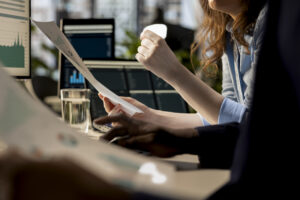 Personas revisando documentos y gr&aacute;ficos en un entorno de trabajo
