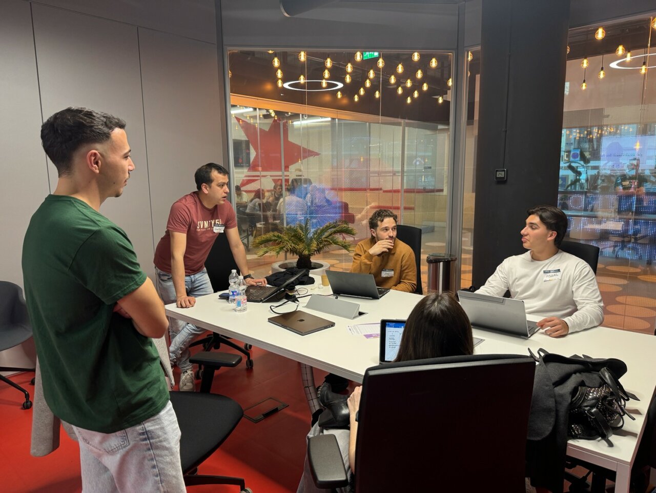 Grupo de j&oacute;venes trabajando en un hackathon sobre WhatsApp en Madrid