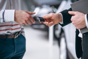 Entrega de llaves de coche entre dos personas en un entorno profesional