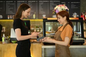 Cliente realizando un pago con un TPV en un bar moderno