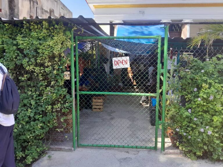 Puerta de un establecimiento con cartel de abierto en Cuba