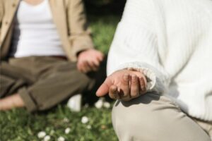 Personas meditando en un entorno natural con manos abiertas